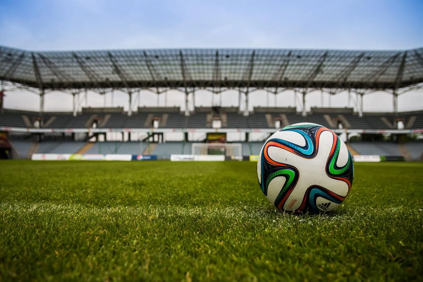 Bola sepak di lapangan hijau stadion